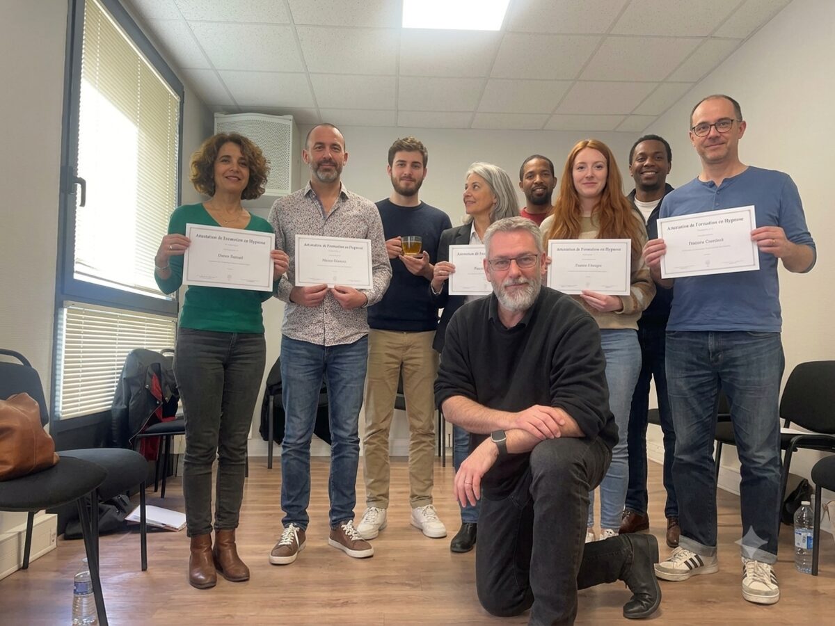 Groupe de stagiaires tenant leur attestation de formation en hypnose